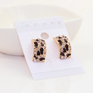 Détail de boucles d'oreilles imprimé léopard avec strass sur carte de présentation
