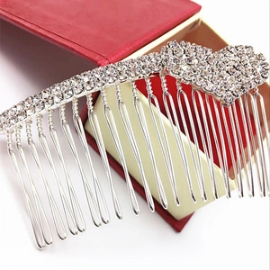 Détails macro d'un peigne à cheveux en argent serti de strass sur un coffret à bijoux rouge