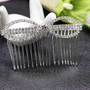 Peigne à cheveux de mariée argenté avec nœud en strass posé sur un support main