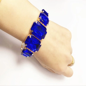 Detail of vintage style gold claw setting with four large rectangular deep blue gemstones