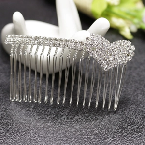 Peigne à cheveux cœur en alliage argenté avec strass blancs sur support main blanc