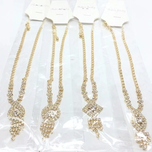 Detail view of four gold-plated rhinestone necklaces with various geometric pendants