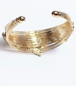 Detailed macro view of gold-plated multi-layer wire bracelet with sparkling rhinestones
