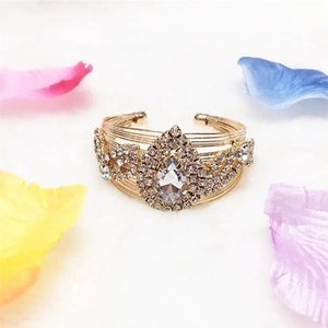Detail of gold-plated wire cuff bracelet with a large pear-shaped crystal center