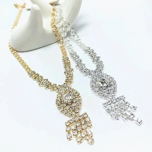 Detailed close-up of crystal tassel necklaces in gold and silver on a hand display