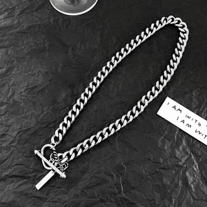 Detail of silver Cuban link chain with T-bar toggle clasp and rectangular metal tag