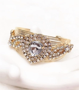Detailed macro view of gold multi-layer wire bracelet with pear-shaped rhinestone