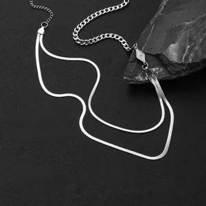 Detail of silver double-layered snake chain and chunky link necklace with diamond-shaped charm