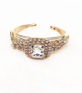 Macro shot of gold-plated multi-wire cuff bracelet featuring large cushion-cut crystal and rhinestones