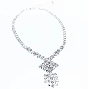 Detail of silver rhinestone necklace with diamond-shaped pendant and tassel drop elements