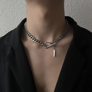 Silver cuban link necklace with rectangle tag and toggle clasp on a black suit
