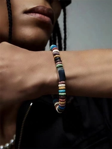 Macro detail of multi-color volcanic stone beads and black metal part on a man wrist