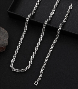 Macro detail of silver stainless steel rope chain with tight spiral texture and link clasp
