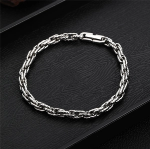 Detailed view of silver braided wheat chain bracelet with secure fold-over clasp