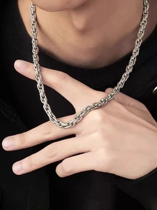 Close-up of men silver stainless steel thick twist chain necklace with woven texture