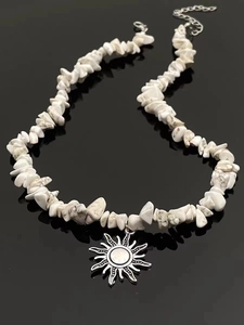 Detail of bohemian sun pendant necklace featuring white natural stone beads and silver clasp