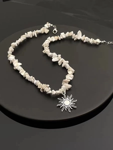 Detail view of Bohemian sun pendant necklace with natural white stone beads and silver chain