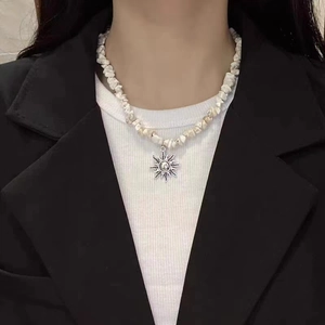 Retro titanium sun pendant necklace with white stone beads on a male model's neck