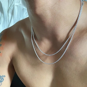 Detailed macro view of sparkling silver titanium steel necklaces layered on neck