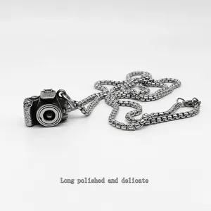 Gros plan du pendentif appareil photo rétro en argent antique sur chaîne box