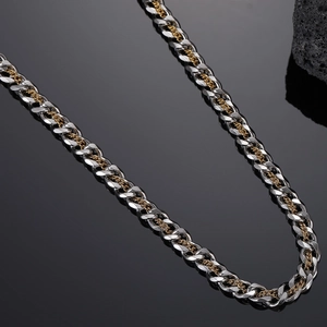 Detail shot of heavy two-tone Cuban link necklace in silver and gold titanium steel