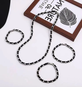 Detail view of titanium steel necklaces and bracelets with black leather woven chain design
