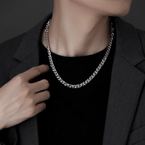 Detailed view of a silver Cuban link necklace with high-polish finish on a male model