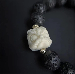 Vue macro de perles en pierre volcanique noire avec charme tête de lion sur le bracelet