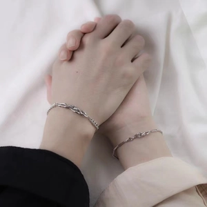 Gros plan de bracelets épines entrelacés en argent pour couples symbolisant la connexion
