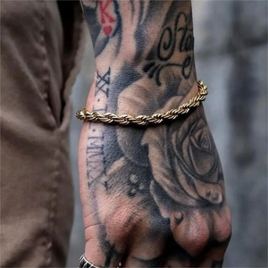 Gros plan d'un bracelet chaîne torsadé en or pour homme de style hip-hop sur le poignet