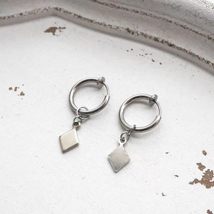 Vue détaillée des boucles d'oreilles argentées avec pendentif losange et fermoir clip