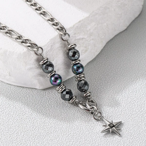 Detailed macro view of titanium steel necklace with obsidian beads and star pendant