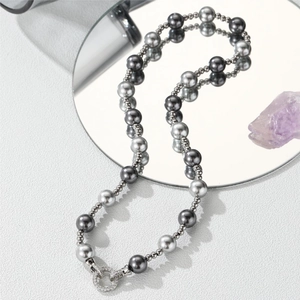 Collier en perles de Tahiti grises avec fermoir en zircon sur surface réfléchissante