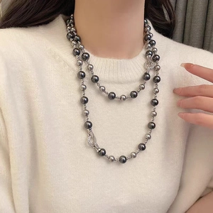 Gros plan sur un collier double rang en perles grises avec fermoir serti de diamants