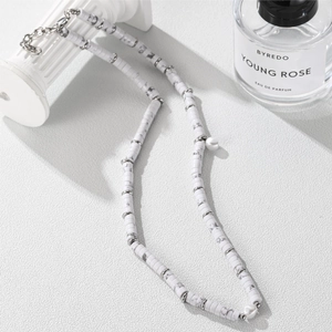 Beaded jasper and pearl necklace with silver spacers on a minimalist white display
