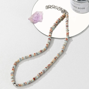 Close-up of natural colorful jasper stone disc necklace with silver metal accents