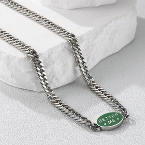 Macro detail of the green enamel pendant with Better Me text on silver curb chain