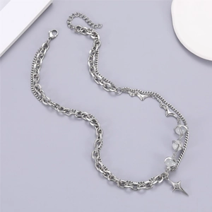 Détail du collier à plusieurs rangs avec étoile croisée argentée, perles et chaînes en acier