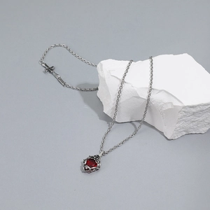 Vintage stainless steel necklace featuring a red gemstone rose pendant and cross charm