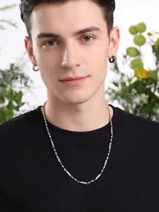 Dettaglio della collana a maglie cilindriche in acciaio inossidabile da uomo e orecchini