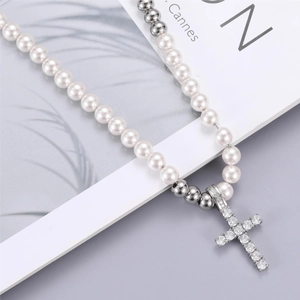 Détail du collier croix avec perles blanches et pierres de zircone cubique étincelantes