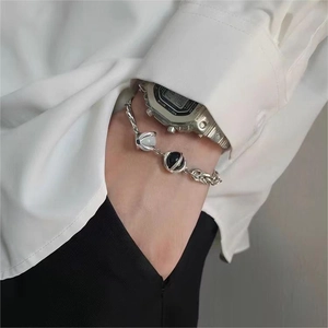 Detailed view of silver chain bracelet with cat eye stones worn on a wrist