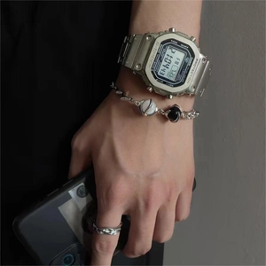 Detail of titanium steel cat eye bracelet paired with a metallic watch and textured ring