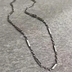 Dettaglio della collana Mobius in acciaio al titanio con motivo a stella incisa