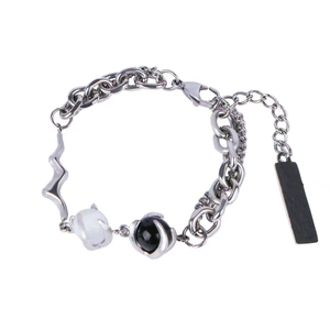 Minimalist stainless steel cat's eye bracelet with black and white beads on white background
