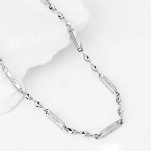 Dettaglio della collana Mobius in acciaio al titanio con targhetta a stella incisa
