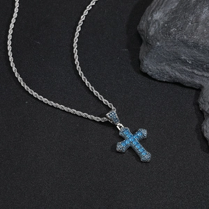 Close-up of hip hop cross pendant with blue cubic zirconia stones on silver rope chain