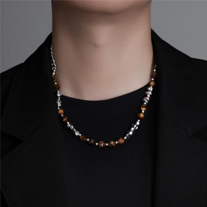 Detail of faceted tiger eye stones and metallic beads necklace worn with black suit
