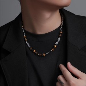 Detail of tiger eye beads and silver stainless steel chain on men's necklace