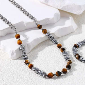 Detailed shot of tiger eye stone and irregular silver beads on white stone background